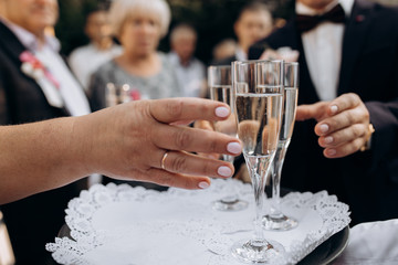Guests are taking champagne from the tray, front view of hands