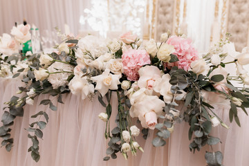 Decorative floral composition on the table made of fresh eucalyptus, roses and hydrangea
