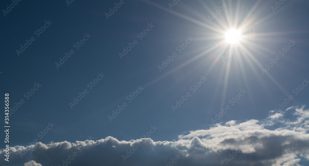 Canvas Prints sun with rays on a background of blue sky with clouds