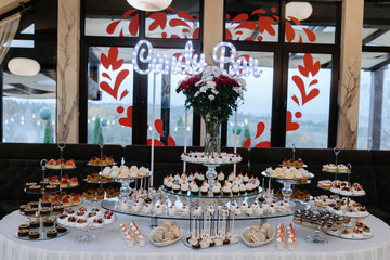 Delicious candy bar with french macarons, cupcakes and desserts at the restaurant