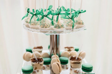 White and mint color desserts stand on the mirror desk