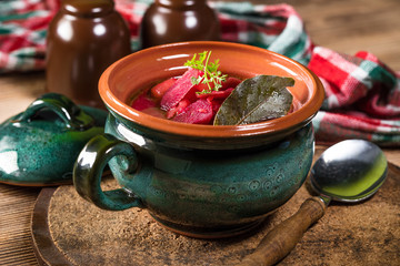 Red borscht soup in bowl.