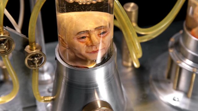 head of a man without a body in a cylindrical glass vessel (flask), in a liquid with air supply (bubbles), similar to a laboratory for experiments, close-up, creepy