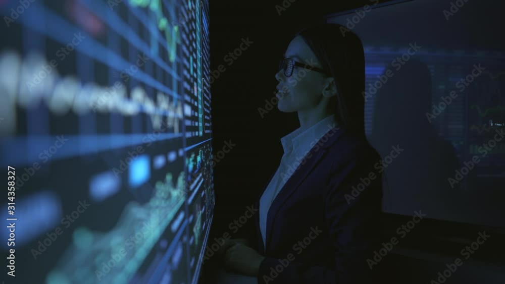 Wall mural The businesswoman working on the black sensor screen in the dark space