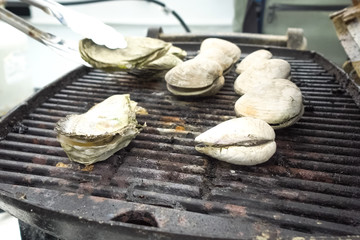 Grilled oysters on grill in the open air.