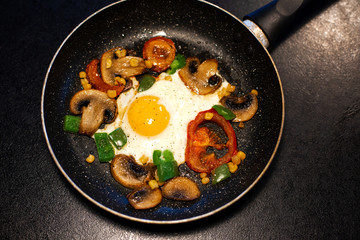 Freshly fried eggs with vegetables in a pan