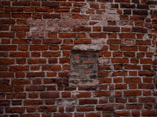 Medieval european red brick wall with bricked up window, abstract vintage grunge background texture.