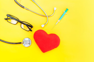 Simply minimal design medicine equipment stethoscope or phonendoscope glasses syringe red heart isolated on trendy yellow background. Instrument device for doctor. Health care life insurance concept