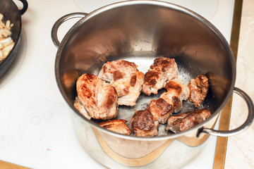 Cooking - fried pieces of meat stacked in a metal pan