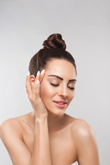 Beauty face model. Beautiful Woman with healthy smooth facial clean skin holding bottle cosmetic...