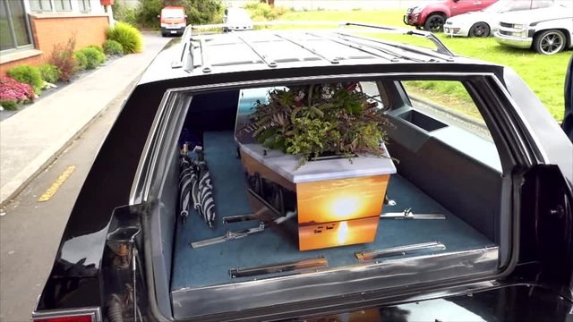 closeup shot of a funeral casket in a hearse or chapel or burial at cemetery