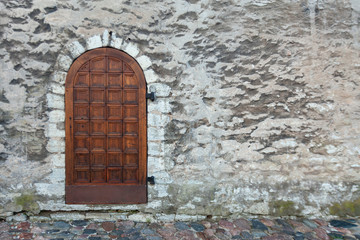 Background image - a wooden door in the wall of an ancient fortress