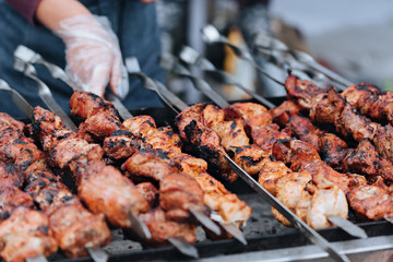 Grilling marinated meat on a grill. Street food festival