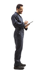 Obraz premium Worker in a uniform writing a document with a clipboard