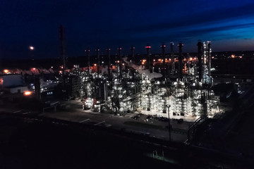 Fototapeta na wymiar Oil refinery at night lit. Construction of an oil industrial fac