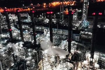 Oil refinery at night lit. Construction of an oil industrial fac