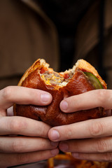 Man eating a hamburger in modern fastfood cafe, lunch concept