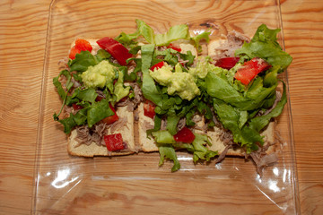 Crispy corn toast served with typical Mexican food spatter cooked with shredded beef, red chili, lettuce and guacamole