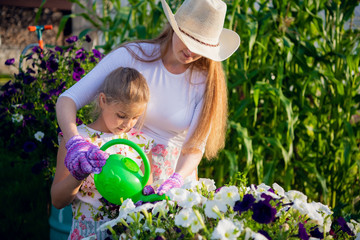 Young girl watering potted flower plant smiling