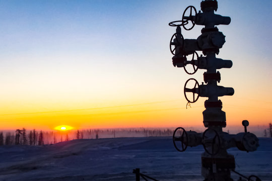 Oil well against the backdrop of sunset. industrial landscape