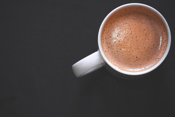white cup of coffee with black wooden background