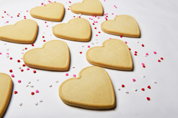 Valentines Day Concept: closeup of fresh baked heart shaped cookies with candy heart sprinkles.