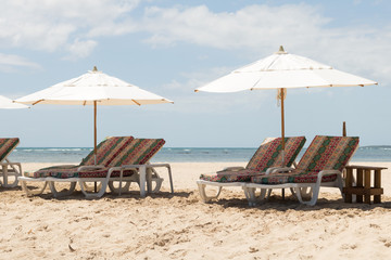 Deserted beach view in hotel resort with beach chairs for lounging and parasol. Shadow. Vacation. Brazil. Bahia.