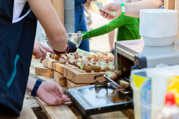 Cooked snails delicacy. French cuisine stuffed snails. Street food festival