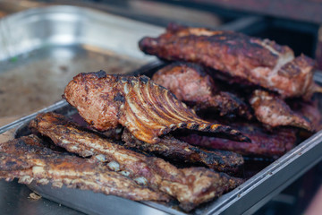 Grilled pork ribs on the grill at street food festival