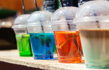 Iced colorful cocktails on wooden table outdoor
