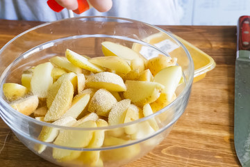 Raw potatoes cutting and peeling on table in a plate