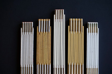 Retro wooden folding rulers arranged as skyscrapers on black, night sky background, for business presentations or use as art.