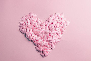 Pink heart confetti on pink background. Festive holiday pastel backdrop. Flat lay. Top view. Copy space