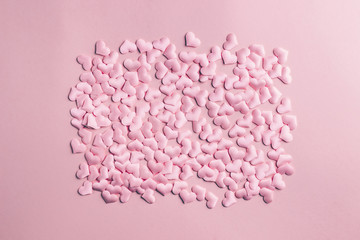 Fototapeta premium Pink heart confetti on pink background. Festive holiday pastel backdrop. Flat lay. Top view. Copy space