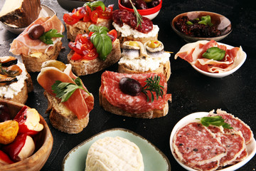 Appetizers table with italian antipasti snacks and wine in glasses. Brushetta or authentic traditional spanish tapas set, cheese variety