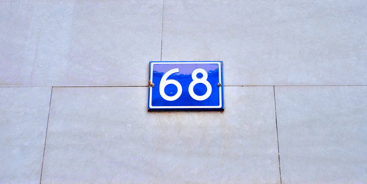 Number 68, sixty-eight, blue plate on pale background.