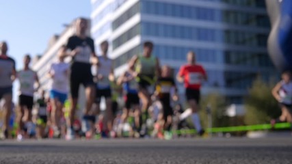 Blurry shot of marathon runners' legs passing the camera