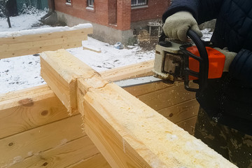 Sawing a groove in a bar. Collecting a house from log house.