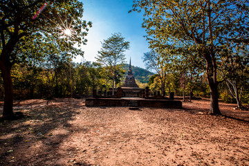 The blurry nature background of the Wat Saphan Hin walkway has long, stone bridges on a hill, with tourists coming to see the beauty in Sukhothai, Thailand.