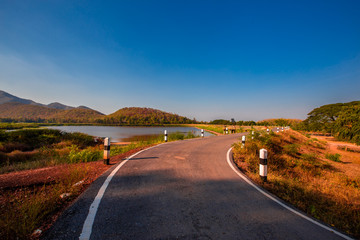 The blurred panoramic nature background of sunlight hitting the lake's surface, grass and wind blowing all the time along the large mountains, ecological beauty and fresh air.
