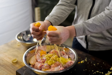Squeezing lemons in a plate with chicken meat. lemon