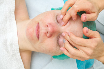 Beautician does eye massage to a young beautiful girl. closeup photo