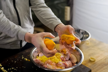Squeezing lemons in a plate with chicken meat. lemon