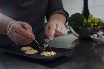 cook makes sandwiches with black caviar.
