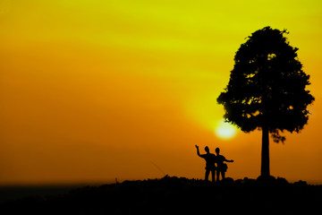 miniature people / toy photography - conceptual valentine holiday illustration. Happy couple holding each other enjoying sunset view bellow a big tree