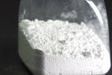 White powder in transparent jar. white powder on the table.