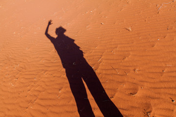 Shadow of a person in a desert dunes