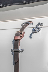 baul de auto de clasico de coleccion con cierre de puerta baul de cuero tipo cinturón y hebilla de metal plateada, detalle, lujo calidad y clase