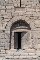 Fototapeta na wymiar Stone door of Qasr al-Azraq (Blue Fortress), fortress located in the desert of eastern Jordan.