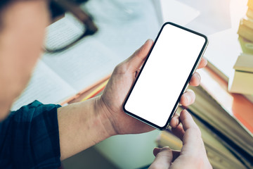 Mockup image blank white screen cell phone.man hand holding texting using mobile on desk at coffee shop.background empty space for advertise text.people contact marketing business,technology 